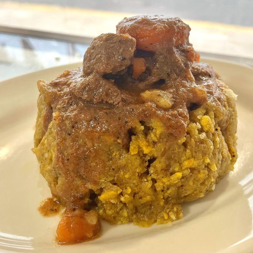 Mofongo with beef stew and carrots on a white plate at Mambo Nando's.