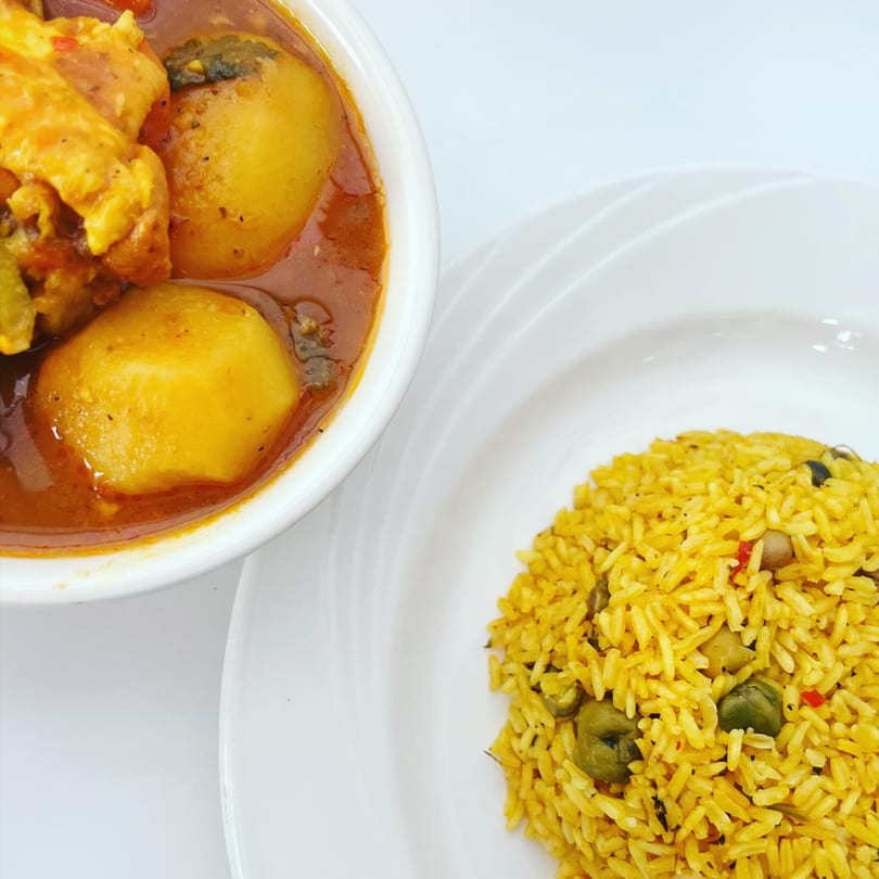 Mambo Nando's Puerto Rican chicken stew with potatoes and yellow rice with pigeon peas.